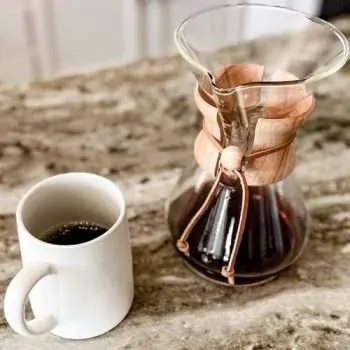 Chemex and coffee mug containing freshly brewed coffee