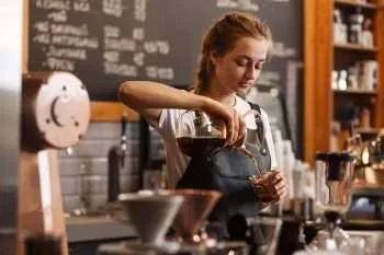 Professional barista in a cafe pouring a cup of coffee from a Chemex