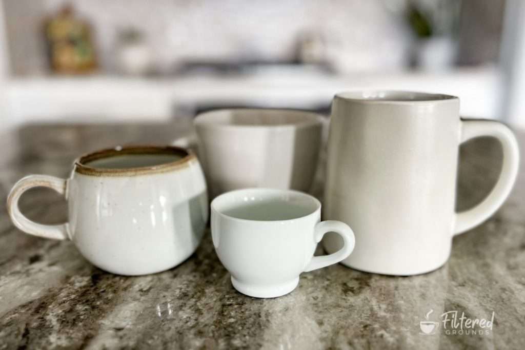 Four coffee cups that are different in shape and size