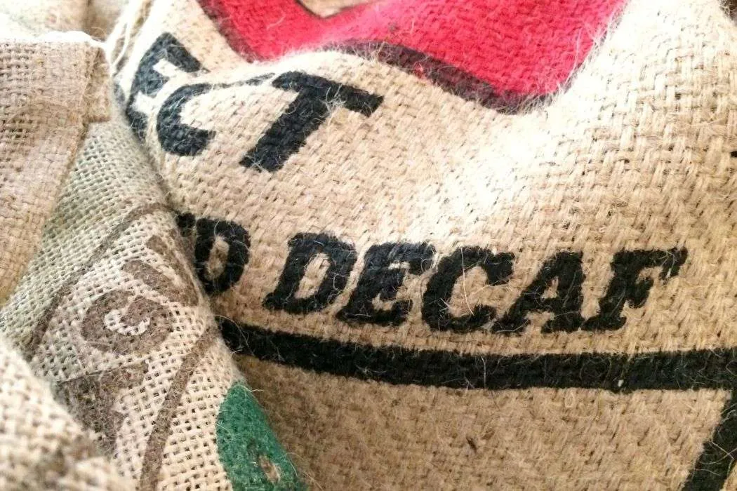 Jute bag with the word "decaf" stamped on the front