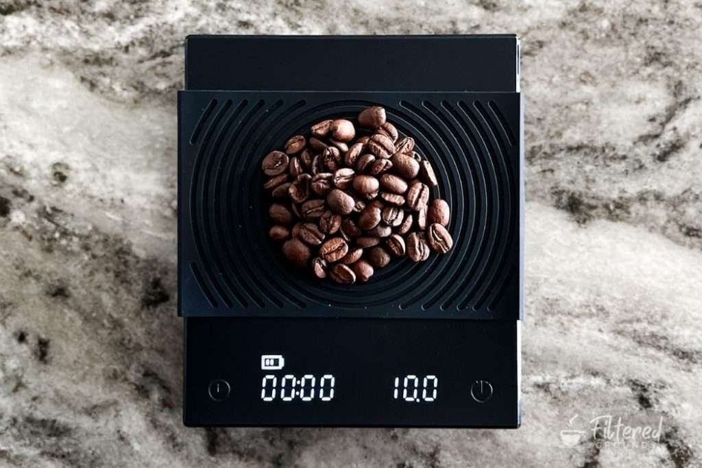 Kitchen scale showing the weight of a pile of coffee beans