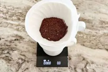 Coffee grounds in a pour-over brewer on a kitchen scale
