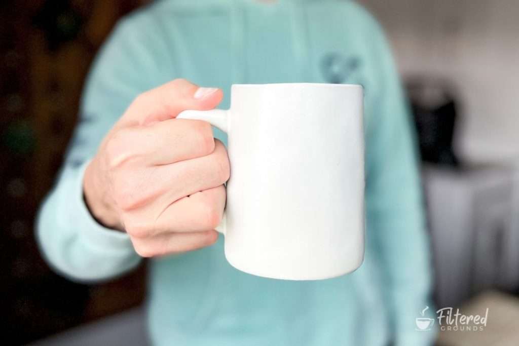 Home barista holding a mug of freshly brewed pour-over coffee