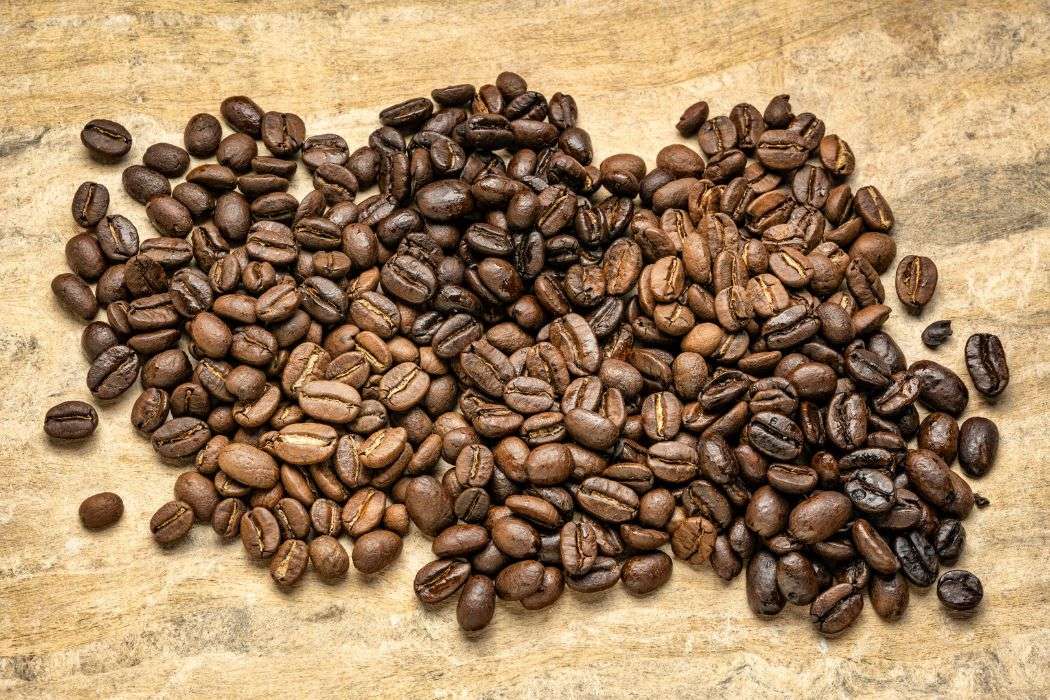 Coffee beans from different origins blended together on a wooden table